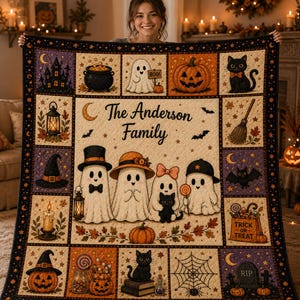 Könnte beinhalten: Eine rechteckige Halloween-Steppdecke mit einem zentralen Feld, das den Text The Anderson Family und vier Geisterfiguren zeigt. Die Decke ist mit verschiedenen saisonalen Motiven wie Kürbissen, schwarzen Katzen, Fledermäusen, einem Kessel und einem Spinnennetz verziert.