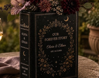 May include: A black book-shaped vase with gold foil detailing, featuring the text "OUR FOREVER STORY", "Olivia & Ethan", and "EST. 10.12.2026" on the front, and "OLIVIA & ETHAN" and "THE START OF ALWAYS" on the spine, filled with dark floral blooms.