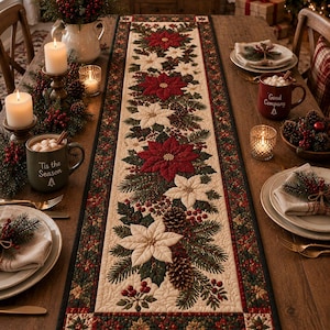 Peut inclure: Un chemin de table matelassé rectangulaire orné d'un motif central de fleurs de poinsettia rouges et blanches, de branches de pin vertes, de pommes de pin et de baies rouges sur fond crème, bordé d'une bordure vert foncé à motif floral.