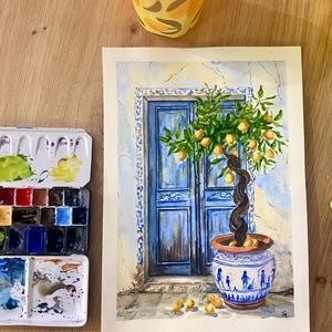 Peut inclure: Une aquarelle représentant une porte bleue vibrante encadrée de carreaux décoratifs, avec un citronnier en pot au tronc torsadé dans un pot en céramique bleu et blanc, et plusieurs citrons jaunes éparpillés sur le sol devant la porte.