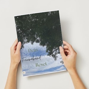Könnte beinhalten: Ein rechteckiges Heft mit einem Umschlag, der ein Foto von grünen Baumzweigen vor einem blauen Himmel mit weißen Wolken zeigt. Der Text "Dein Feierabend-Reset" ist in dunkelgrünen Buchstaben auf dem Umschlag des Hefts aufgedruckt.