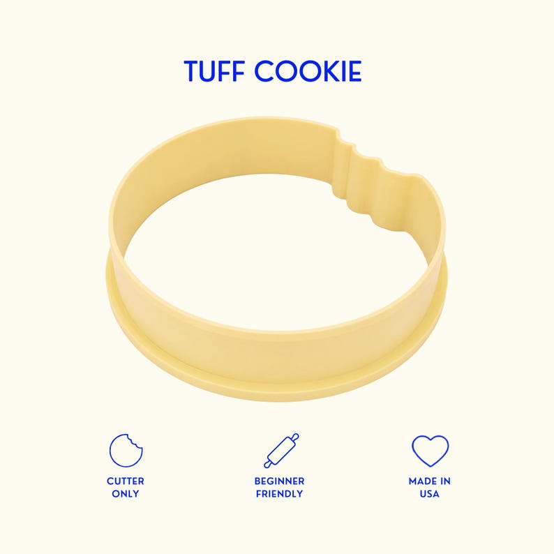 May include: A pale yellow circular cookie cutter featuring a bite mark design on one side. The text TUFF COOKIE is printed above the cutter. Below are three icons with the text CUTTER ONLY, BEGINNER FRIENDLY, and MADE IN USA in blue ink.