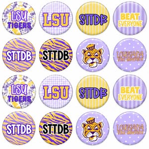 May include: A collection of twenty-four circular pin-back buttons featuring purple and gold designs. The buttons display various graphics including the text LSU, STTDB, BEAT EVERYONE, SEE YOU IN DEATH VALLEY, LOUISIANA STATE UNIVERSITY, and tiger motifs.