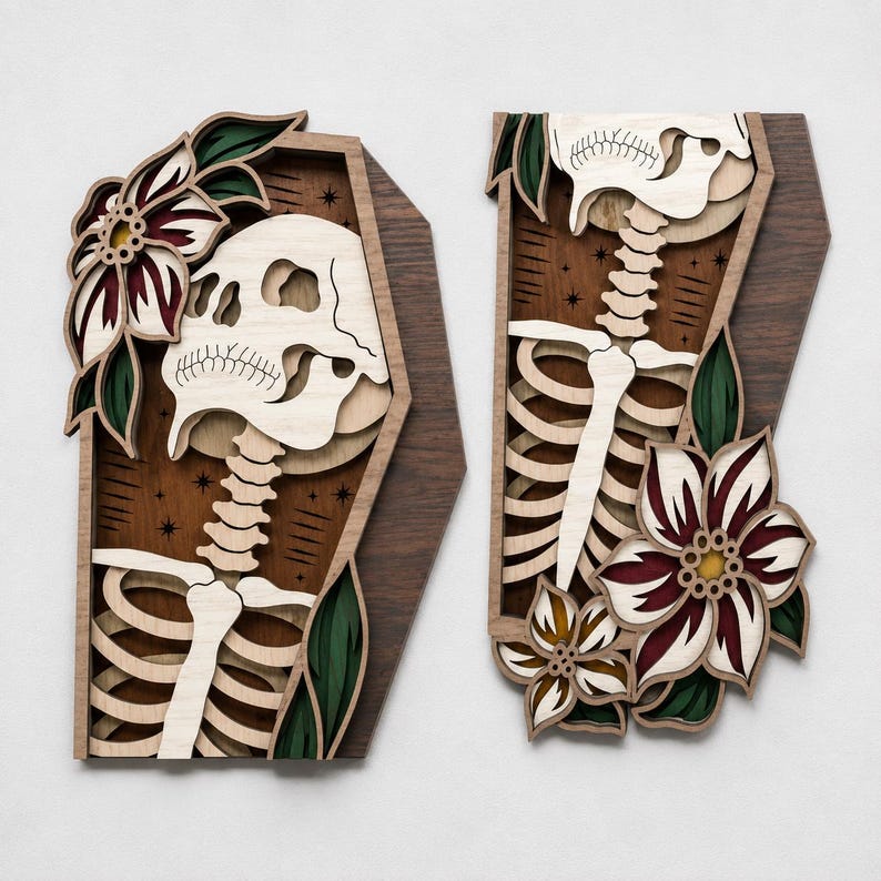 May include: Two layered wooden wall art pieces shaped like coffins. Each piece features a light-colored wooden skeleton, dark brown wood background with etched stars, and multi-layered flowers in shades of deep red, green, and cream.