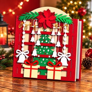 May include: A three-dimensional Christmas greeting card featuring a red lattice frame, a green pine tree, a large red poinsettia, hanging white bells, string lights, and two cream-colored gift boxes with red ribbons, all crafted from layered paper.