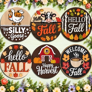 May include: Six circular wooden signs featuring autumn themes. Designs include a goose with a pumpkin, a cow with leaves, a Hello Fall sign with trees, a hello FALL sign with leaves, a red barn with pumpkins, and a coffee mug with leaves.