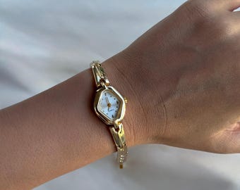 Reloj de pulsera dorado para mujer, movimiento de cuarzo, diseño minimalista.