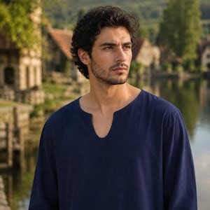 May include: A dark blue long-sleeved shirt featuring a rounded neckline with a vertical slit opening at the center. The garment is constructed from a solid-colored fabric and has a relaxed fit, covering the shoulders and upper torso area.