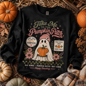 May include: A black crewneck sweatshirt featuring a graphic of a ghost wearing a pink beanie and holding an orange pumpkin. The text reads Take Me To The Pumpkin Patch, Just Here For The Pumpkins, Pick Your Own Good Times, Hay Rides, Pumpkin Patch, Hot Cider, and Happy Haunting, surrounded by flowers and a checkered pattern.