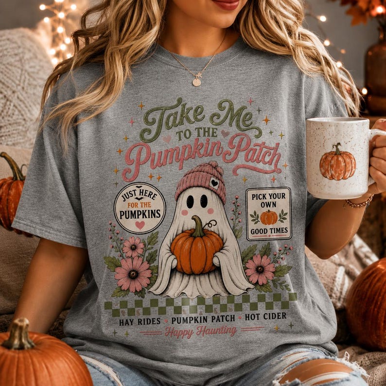 May include: A heather gray t-shirt featuring a graphic of a ghost wearing a pink beanie and holding an orange pumpkin. The text reads Take Me To The Pumpkin Patch, Just Here For The Pumpkins, Pick Your Own Good Times, Hay Rides, and Happy Haunting.
