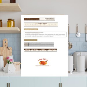 Op de afbeelding: Een wit document met tekst en afbeeldingen, waaronder de titel "LMA Flavors" en "Pad Thai Végétarien". Het document ligt op een aanrecht met een blauwe tegelachterwand en houten planken.