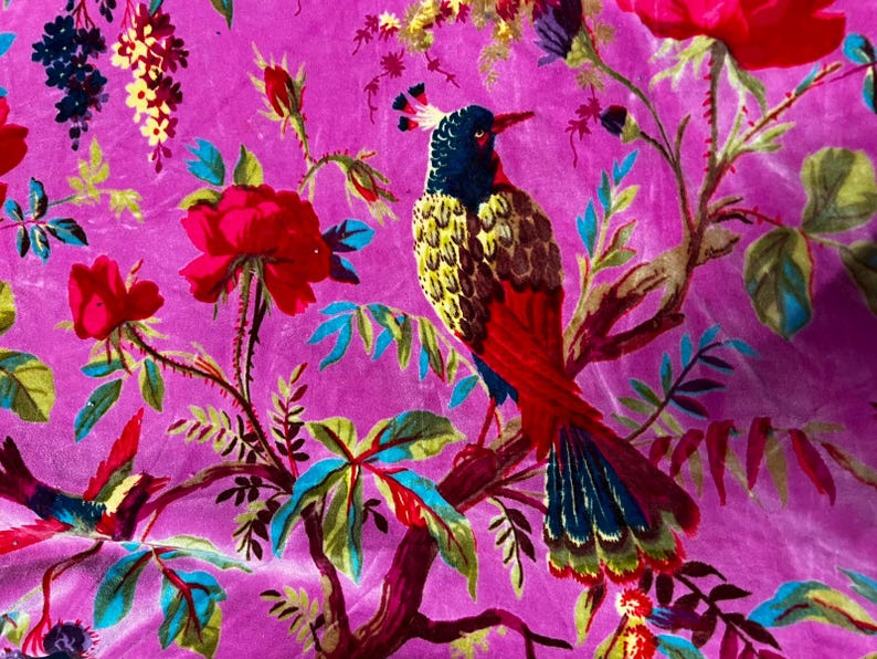 Puede incluir: Una tela de color magenta vibrante con un patr&oacute;n repetitivo de aves coloridas con cabezas azul oscuro, pechos amarillos y colas rojas posadas en ramas. El dise&ntilde;o incluye grandes rosas rojas, hojas verdes y peque&ntilde;os racimos de flores amarillas.