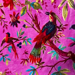 Puede incluir: Una tela de color magenta vibrante con un estampado bot&aacute;nico detallado que muestra dos aves posadas en ramas. El dise&ntilde;o incluye follaje rojo, azul y verde, flores de color p&uacute;rpura oscuro y bayas. El ave m&aacute;s grande tiene una cresta y plumaje iridiscente.