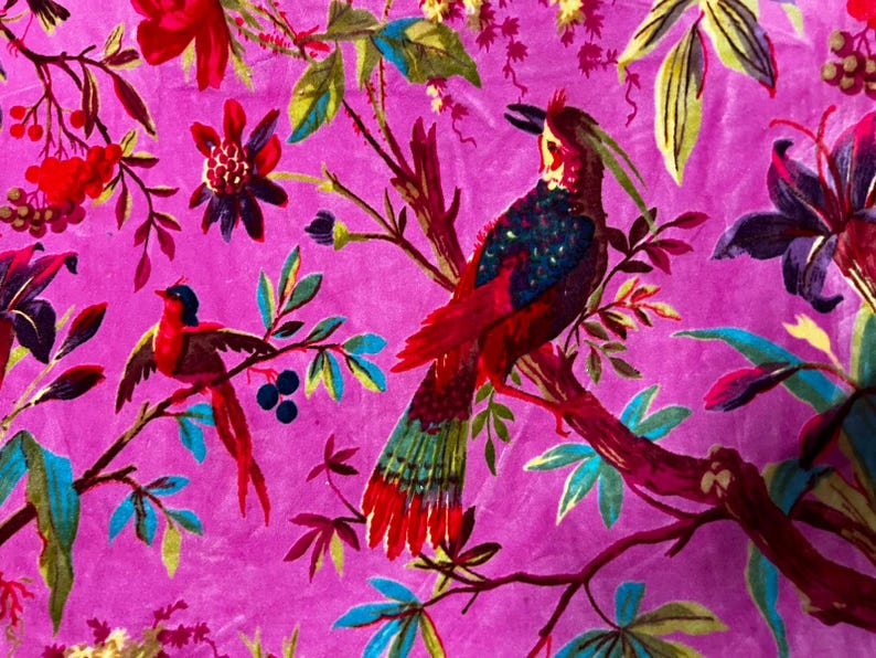 Puede incluir: Una tela de color magenta vibrante con un estampado bot&aacute;nico detallado que muestra dos aves posadas en ramas. El dise&ntilde;o incluye follaje rojo, azul y verde, flores de color p&uacute;rpura oscuro y bayas. El ave m&aacute;s grande tiene una cresta y plumaje iridiscente.