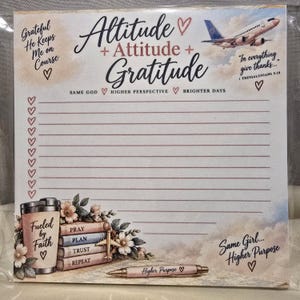 Puede incluir: Un bloc de notas cuadrado con el texto Altitude + Attitude + Gratitude, un avión y una lista de verificación. La parte inferior muestra un vaso con Fueled by Faith, libros con Pray, Plan, Trust, Repeat y un bolígrafo con Higher Purpose.