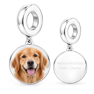 Puede incluir: Dos dijes circulares de tono plateado con acabado pulido. El dije de la izquierda presenta una fotografía a color de un perro golden retriever. El dije de la derecha tiene una superficie lisa y reflectante con el texto "Personalisiertes Foto-Charm".