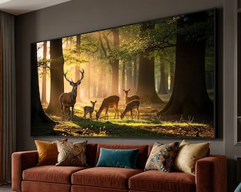 May include: A large framed canvas print showing a forest scene with deer. The artwork features a buck with large antlers and several does and fawns grazing in a sunlit clearing. The print is displayed above a rust-coloured sofa with decorative cushions.