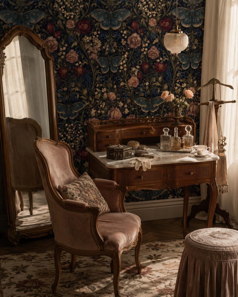 May include: A wooden vanity table with a marble top, a velvet armchair, a tall floor mirror, and a small stool. The vanity holds glass perfume bottles, a small box, and gloves. The wall features dark wallpaper with blue butterflies and flowers.