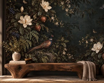 May include: A long, natural-edge wooden bench sits before a dark botanical mural featuring a pheasant, white magnolia flowers, and pomegranates. A beige throw blanket drapes over one end, while two stacked books and a ceramic vase rest on the other.