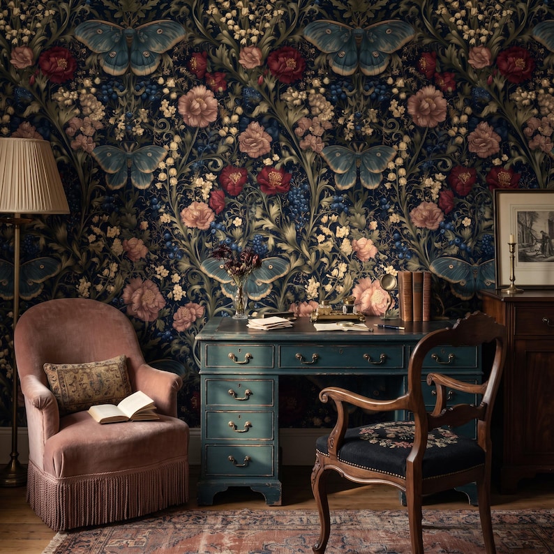 May include: A dark blue wallpaper featuring a repeating pattern of large blue butterflies, pink roses, and small white flowers. The scene includes a pink velvet armchair with fringe, a teal wooden desk with drawers, and a wooden chair with a black seat.