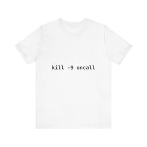 Può includere: Una t-shirt bianca a maniche corte con il testo nero "kill -9 oncall" stampato in un carattere monospazio al centro del petto. Il capo presenta un girocollo e una vestibilità standard, realizzato in tessuto bianco a tinta unita.