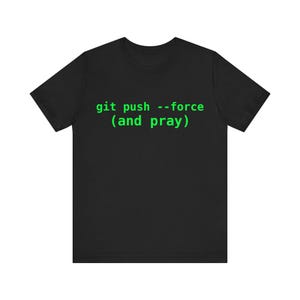 May include: Black t-shirt featuring the green text "git push --force (and pray)". The text is in a monospace font, often used in coding. The t-shirt has a crew neck and is likely made from a soft fabric.