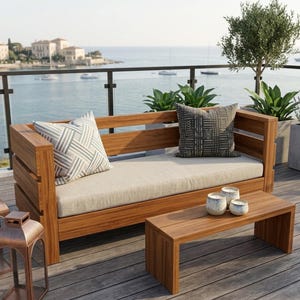 Può includere: Un divano da esterno in legno con un cuscino di seduta beige chiaro, un cuscino decorativo a motivi bianchi e grigi e un cuscino a motivi geometrici neri e bianchi. Una panca in legno abbinata si trova davanti con tre portacandele in ceramica.