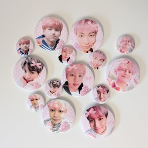 May include: A selection of round buttons with pink themes, each displaying portraits of different people. The buttons are of varying sizes and adorned with pink bows and floral details. The background features a light pink polka dot design.