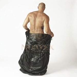 May include: A black leather garment featuring a series of silver-toned metal eyelets and vertical straps. The piece has a structured waistband with visible stitching and a long, flowing skirt section that extends downward with multiple fasteners.