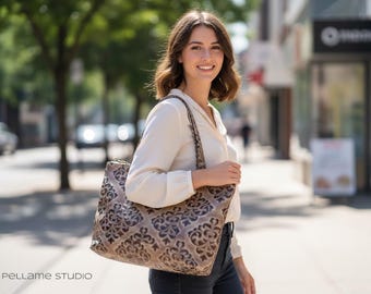 May include: A large tote bag featuring a tan and dark brown damask-style pattern with two shoulder straps. The bag has a rectangular shape and is constructed with a textured surface. The text PELLAME STUDIO is visible in the bottom left corner.