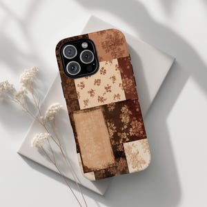 Puede incluir: Una funda rectangular para smartphone con un diseño de patchwork de varios patrones florales en tonos marrón, beige y crema. La funda tiene un recorte para un sistema de cámara de triple lente y botones laterales negros.