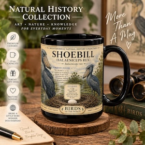 May include: A black ceramic mug featuring a Shoebill bird illustration, a nest with an egg, and text including "Shoebill (Balaeniceps rex)", "A Majestic Hunter", and "Birds of the World". The mug has a 15 oz capacity and a glossy finish.