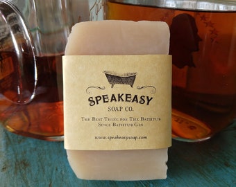 May include: A bar of natural soap with a brown paper label that reads "Speakeasy Soap Co. The Best Thing for the Bathtub Since Bathtub Gin www.speakeasysoap.com". The label features a black and white illustration of a bathtub.