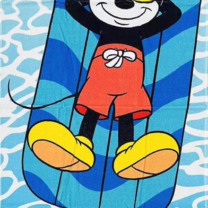 May include: A beach towel featuring Mickey Mouse relaxing on a blue and white striped float, wearing yellow sunglasses and red shorts. The word "CHILLIN'" is printed in large, colorful letters at the bottom. A fun, summery design.