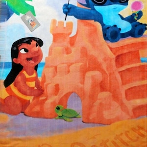 May include: Beach towel featuring a colorful illustration of Lilo and Stitch at the beach. Stitch wears sunglasses and holds a flag and ice cream. Lilo is next to a sandcastle. The words "Lilo" and "Stitch" are written in the sand.