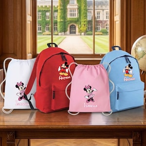 May include: Two backpacks and two drawstring bags featuring Disney characters. A red backpack and a white drawstring bag display Mickey and Minnie Mouse with the name Arthur and Isabella. A light blue backpack and a pink drawstring bag also feature Mickey and Minnie Mouse with the names Arthur and Isabella.
