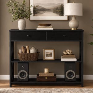 May include: A black rectangular console table featuring two top drawers with round knobs, a middle shelf, and a bottom shelf. The table has X-shaped side supports and a flat surface, providing storage and display space for various home decor items.
