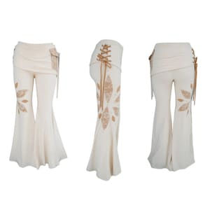 May include: White bell-bottom trousers with a brown lace design and a lace-up back. The trousers have a wrap-around style waistband.