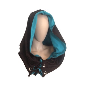 May include: A black hooded scarf with a turquoise lining and silver grommets. The scarf is tied with a drawstring.