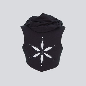 May include: Black sleeveless hooded vest with a white flower cutout on the back.