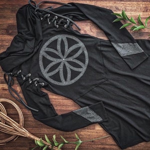 May include: Black hooded long-sleeved dress with a grey flower of life design and grey accents on the sleeves. The dress has a lace-up detail on the side.