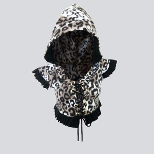 May include: A black and white leopard print hooded top with a black lace-up front and black ruffle trim.
