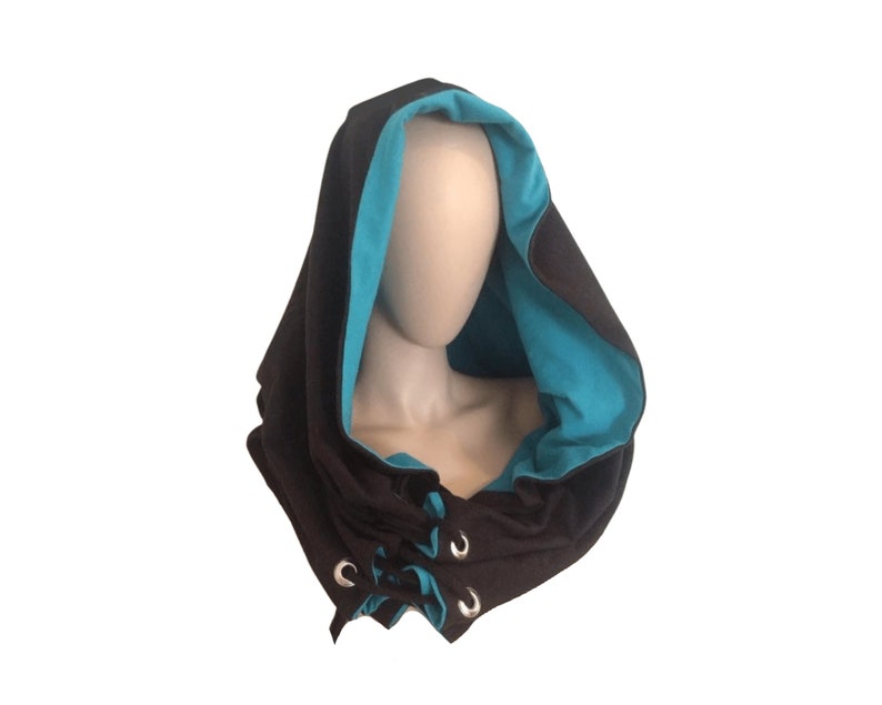 May include: A black hooded scarf with a turquoise lining and silver grommets. The scarf is tied with a drawstring.