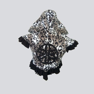 May include: A black and white leopard print hooded jacket with a black ruffle trim and a black embroidered flower design on the back.