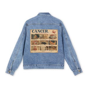 Peut inclure: Veste en jean bleu clair avec un graphique de style vintage au dos. Le graphique présente le mot "CANCER" au-dessus d'un collage d'images et de texte. La veste a un design classique avec des boutons et des poches.