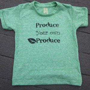 Op de afbeelding: Groen T-shirt met de tekst "Produce your own Produce" en een groene bladafbeelding.