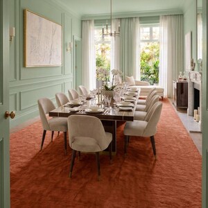 May include: A formal dining room with a long, dark wood table set for a meal. Beige chairs surround the table, and a rust-colored rug covers the floor. The walls are painted a light green, and large windows offer a view of the outdoors.
