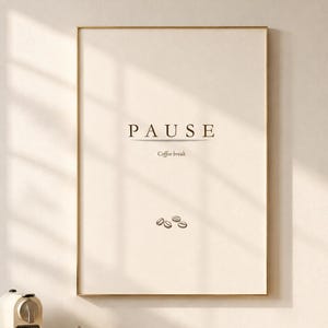 May include: A rectangular wall art print in a thin gold frame featuring a cream-colored background with the word PAUSE in dark brown capital letters, the text Coffee break below it, and three small brown coffee bean illustrations at the bottom.