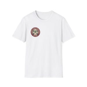 May include: A white short-sleeve t-shirt featuring a circular logo on the left chest. The logo has a maroon border with the text "PLANT BASED ATHLETICS" and "EST. 2026" surrounding a central graphic of two crossed dumbbells and a green leaf.