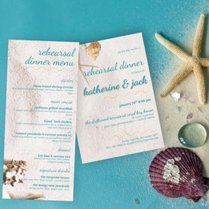 Pode incluir: Dois cartões de papel retangulares com um menu e convite para o jantar de ensaio de Katherine e Jack. Os cartões têm um fundo com textura de areia e texto em turquesa, acompanhados por uma estrela-do-mar bege e uma concha roxa.